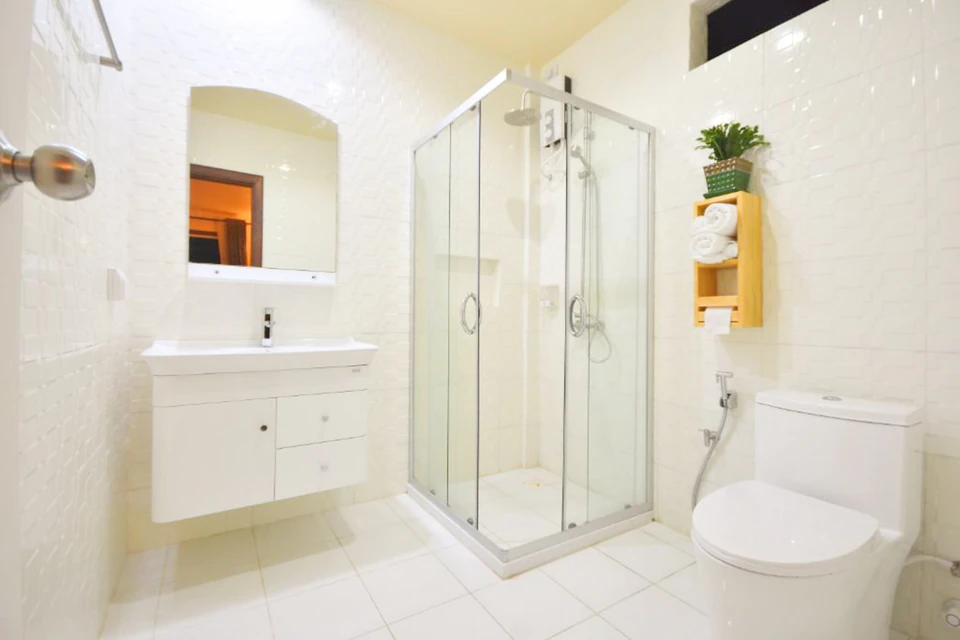 Bathroom with glass shower, vanity, mirror, and toilet