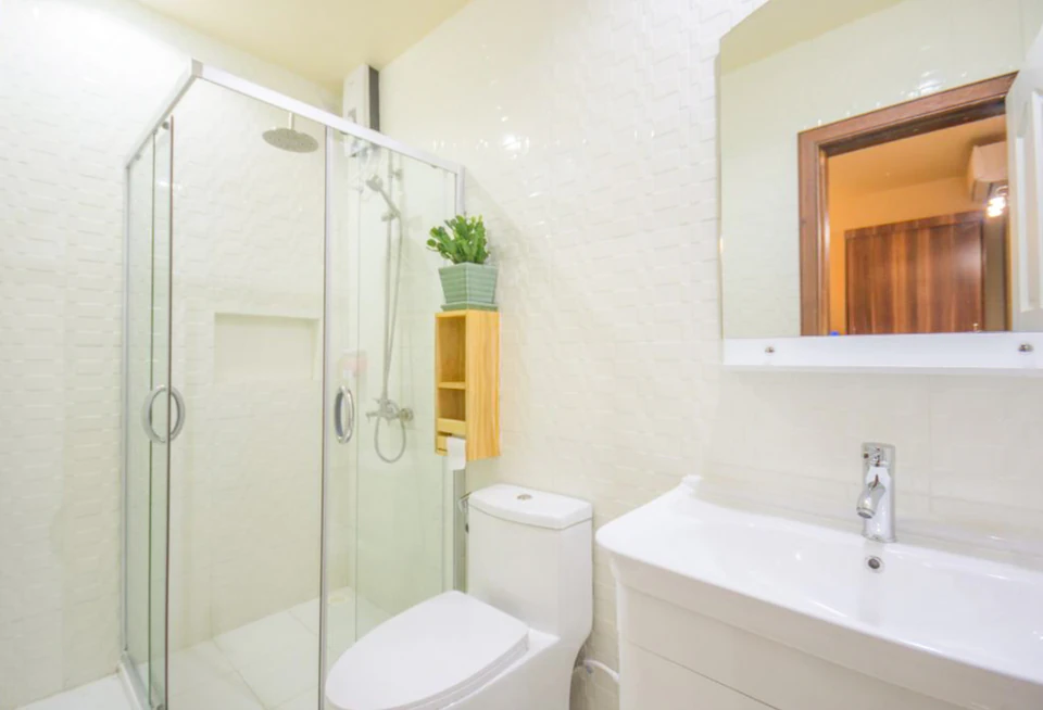 Alternate angle of a guest bathroom with glass shower, vanity, and toilet