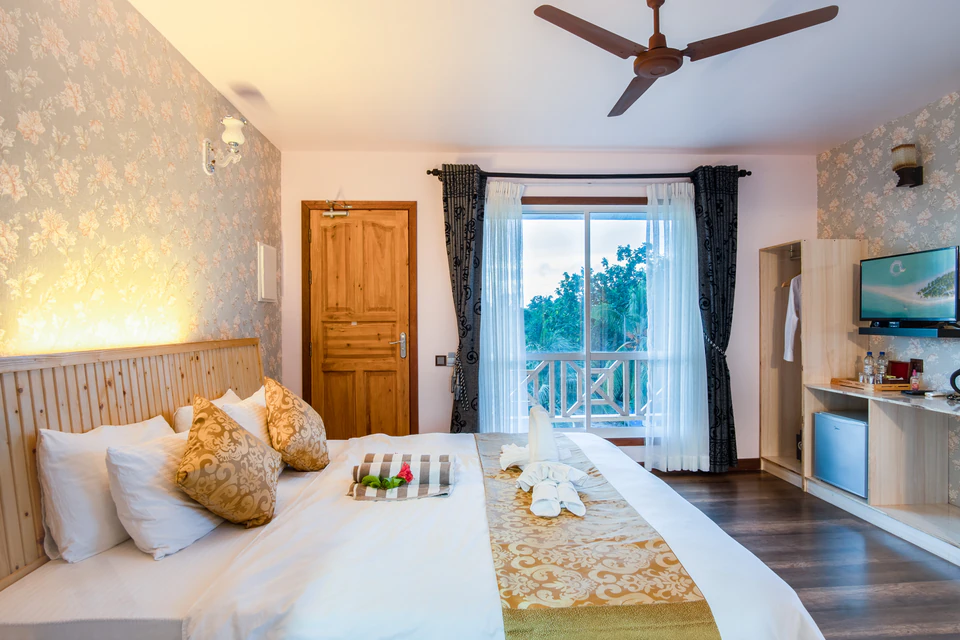 View across the double bed toward the balcony doors