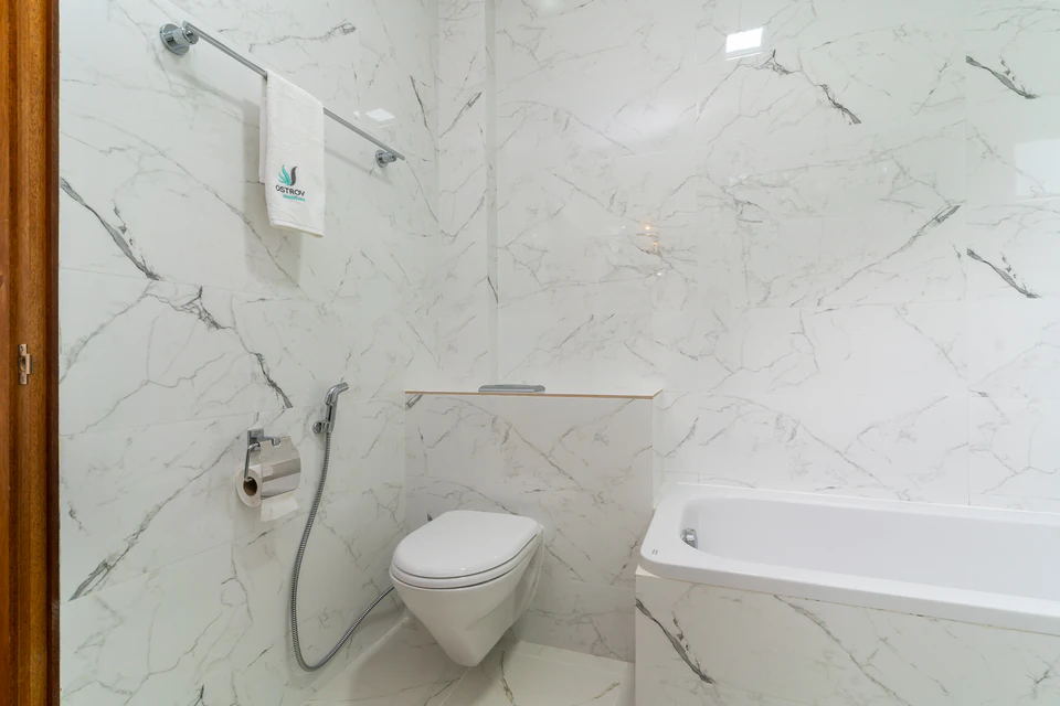 Wide view of the bathtub and wall-mounted toilet