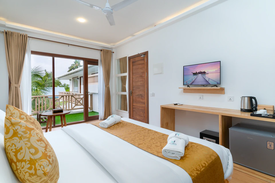 Suite bedroom with double bed, television, and balcony doors