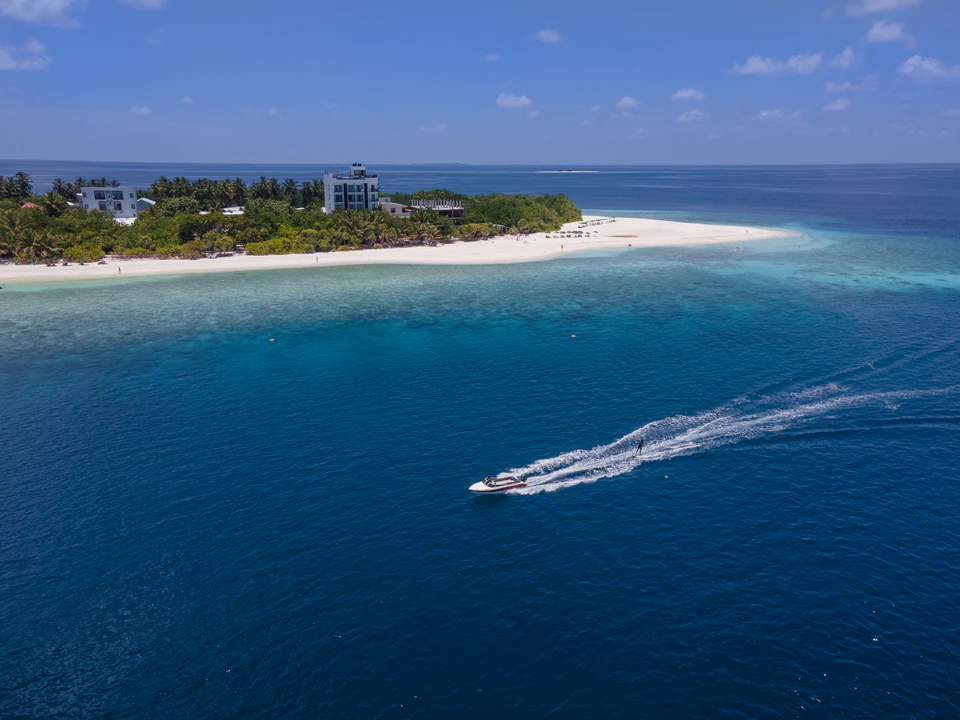 Aerial view of a speedboat passing the Ukulhas coastline